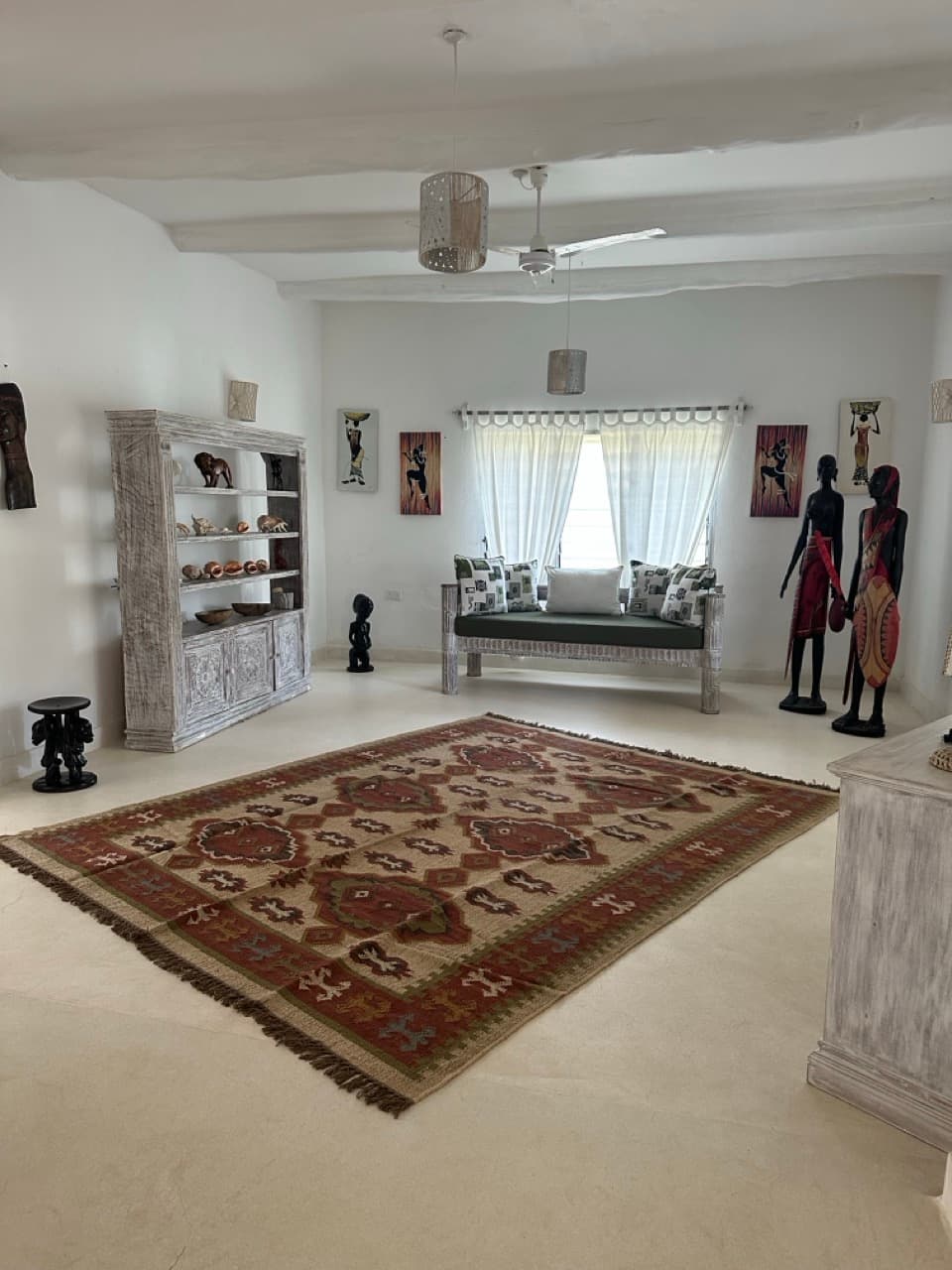 Living room with kilim rugs and African art, Villa Chris House Watamu