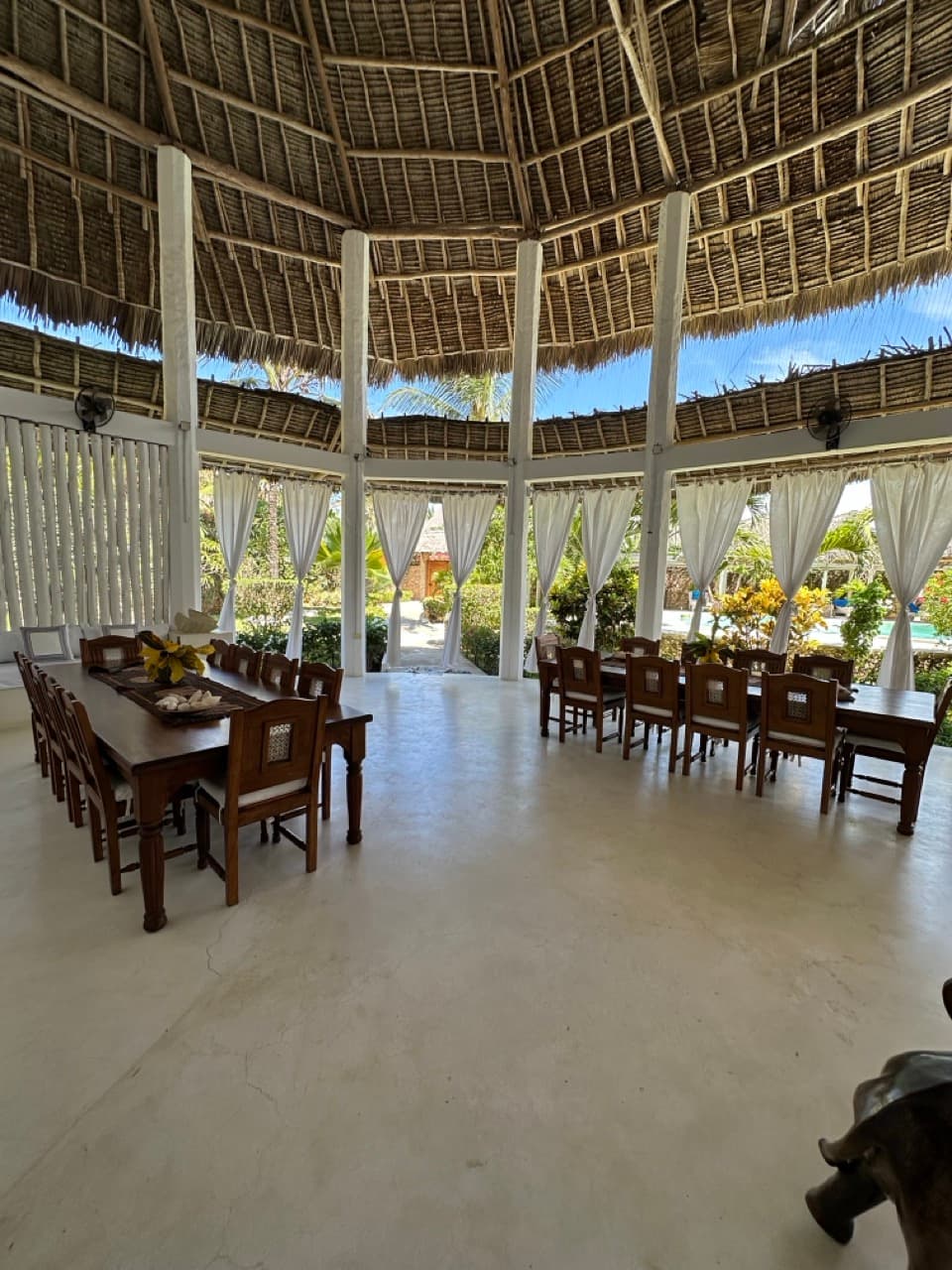 Thatched-roof dining veranda overlooking the tropical garden